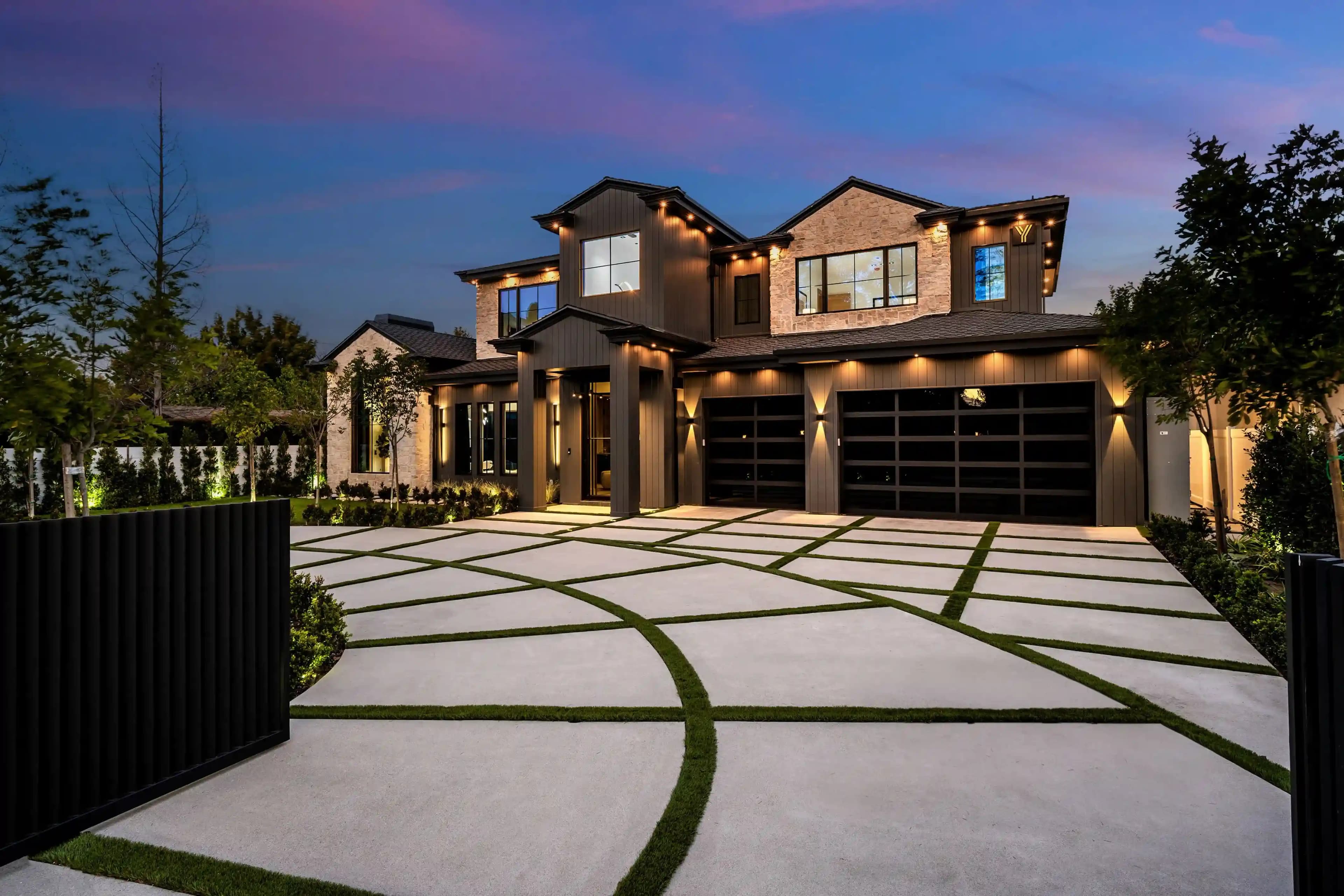 Modern luxury home at dusk with warm interior lighting